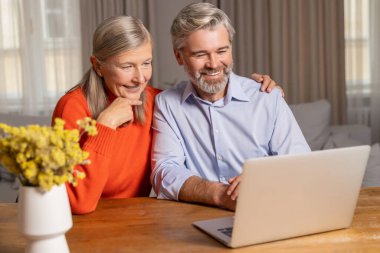 Görüntülü arama. Gülümseyen olgun bir çift görüntülü arama yapıyor.