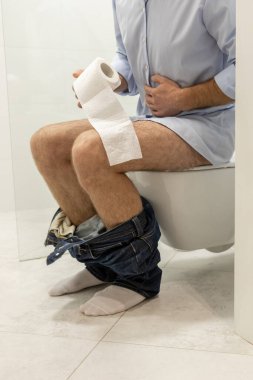Hazımsızlık. Adam tuvalette oturuyor ve sindirim sorunları yaşıyor.