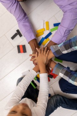 Jenga. Çocuklar ve babaları yerde Jenga oynuyorlar.
