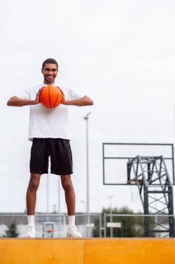 Basketbolcu. Uzun boylu, yakışıklı, elinde top olan kendine güvenen bir genç.