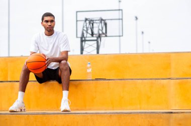 Başarısızlık. Spor kıyafetli bir adam maçtan sonra üzgün bir bakışla oturuyor.