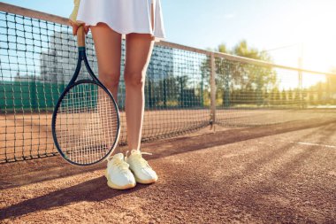 Tenis mi? Tenis kortunda beyaz gömlekli bayan tenisçi.