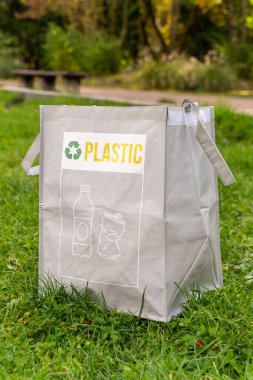 Yeşil parktaki kağıt çöplerini ayırmak için çanta