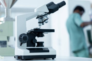 Laboratuvardaki biyolojik örneklerin analizi için tıbbi mikroskop merceğine yakın çekim