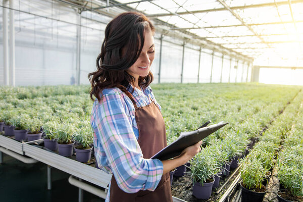 Контроль качества. Руководитель оранжереи проверяет растения и делает заметки