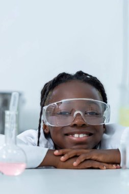 Afro-Amerikalı bilim adamı mataranın arkasına saklanıp laboratuarda örnek analizi yapıyor.