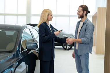 Yeni müşteri. Kadın satış temsilcisi erkek bir müşteriyle konuşuyor ve olaya dahil olmuş gibi görünüyor.