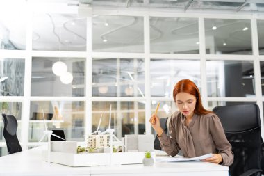 Yeni proje çalışması. Sürdürülebilir yeni bir inşaat projesi üzerinde çalışan genç bayan mimar.