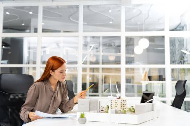 Yeni proje çalışması. Sürdürülebilir yeni bir inşaat projesi üzerinde çalışan genç bayan mimar.