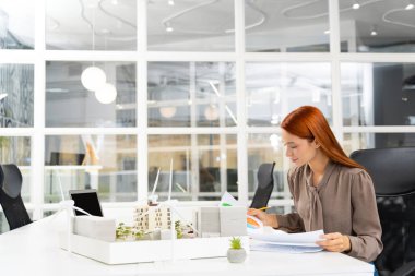 Yeni proje çalışması. Sürdürülebilir yeni bir inşaat projesi üzerinde çalışan genç bayan mimar.