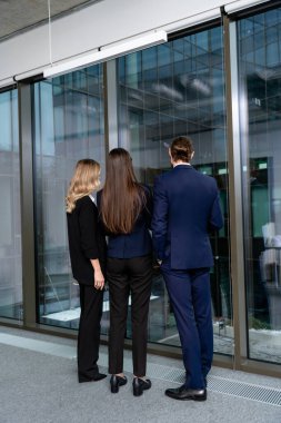 Ofiste. Ofiste bir grup insan pencerenin yanında duruyor.