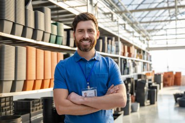 Sakallı, gülümseyen adam saksı satıyor saksı ya da perakende mağazasında saksı satıyor.