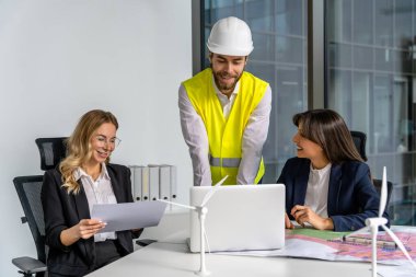 Yeşil enerji. Ofiste çalışan bir grup insan yeni bir yeşil enerji projesi üzerinde çalışıyor.