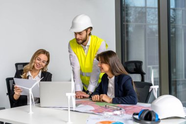 Yeşil enerji. Ofiste çalışan bir grup insan yeni bir yeşil enerji projesi üzerinde çalışıyor.