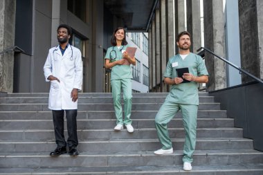 Doktorlar. Laboratuvar önlüklü doktorlar merdivenlerde kendinden emin görünüyorlar.