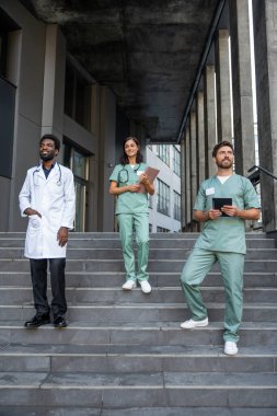 Doktorlar. Laboratuvar önlüklü doktorlar merdivenlerde kendinden emin görünüyorlar.