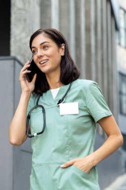 Bir doktorla telefon görüşmesi. Genç bayan doktor bir hastayla telefonda konuşuyor ve ilgili ve arkadaş canlısı görünüyor.