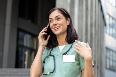 Bir doktorla telefon görüşmesi. Genç bayan doktor bir hastayla telefonda konuşuyor ve ilgili ve arkadaş canlısı görünüyor.