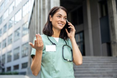 Teletıp. Elinde telefon olan laboratuvar önlüklü genç bir kadın doktor.