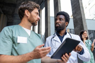 Hasta vakası. İki erkek doktor hasta durumunu tartışıyor ve ilgili görünüyor.