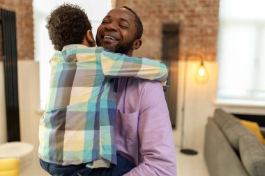 Aile değerleri. Baba oğul sarılıyor, mutlu görünüyor ve eğleniyor.