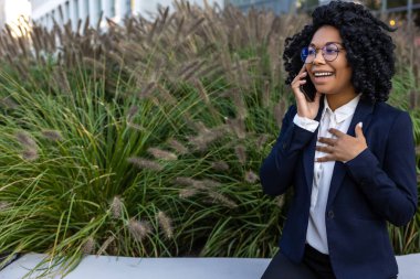 Business woman. Good-looking business woman in a nice suit with a phone in hands clipart