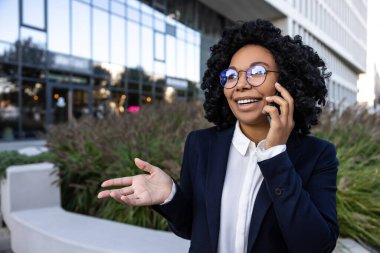 Conversation with client. Elegant good-looking business woman talking on the phone clipart