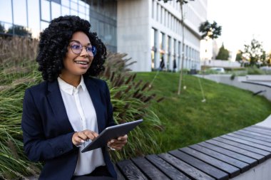Dijitale. Ofis bölgesinde elinde tabletle esmer bir iş kadını.