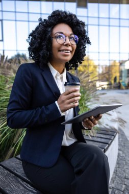 Sabah kahvesi. İş kadını tablet üzerinde çalışıyor ve sabah kahvesi içiyor.