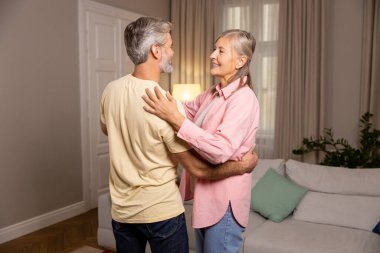 Romantik çift. Mutlu olgun çift evde dans ediyor ve romantik hissediyorlar.