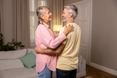 Romantik çift. Mutlu olgun çift evde dans ediyor ve romantik hissediyorlar.