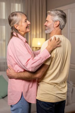 Romantik çift. Mutlu olgun çift evde dans ediyor ve romantik hissediyorlar.