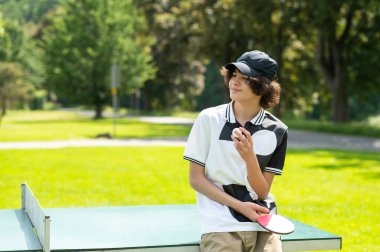 Boş zaman. Siyah şapkalı adam masa tenisi oynuyor ve eğleniyor.