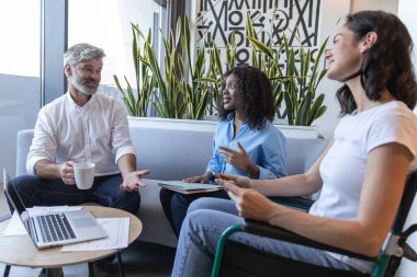 Engelli kişi de dahil olmak üzere çeşitli çalışanlardan oluşan bir grup ile iş görüşmesi, iş yeri stratejisi üzerine takım tartışması yapmak