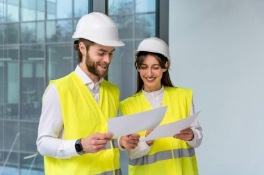 Sürdürülebilirlik projesi. Sarı yelekli iki genç mühendis yeni sürdürülebilirlik projesini tartışıyor.