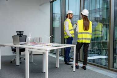 Dayanıklılık. Ofiste yeni bir yeşil enerji projesi üzerinde çalışan iki mühendis.