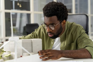 İş günü. Genç Afrikalı Amerikalı mimar bir proje üzerinde çalışırken konsantre olmuş görünüyor.