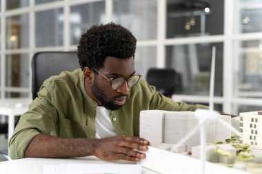 İş günü. Genç Afrikalı Amerikalı mimar bir proje üzerinde çalışırken konsantre olmuş görünüyor.