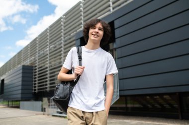 Stree 'deki öğrenci. Uzun boylu, esmer, beyaz bir öğrenci. Sırt çantasıyla sokakta yürüyor.