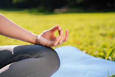 Meditasyon. Kadın parkta oturmuş meditasyon yapıyor.