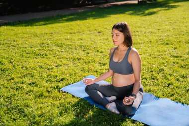 Meditasyon. Kadın parkta oturmuş meditasyon yapıyor.