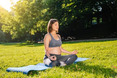 Meditasyon. Kadın parkta oturmuş meditasyon yapıyor.