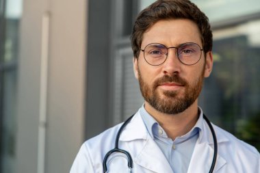 Erkek doktor. Gözlüklü ve laboratuvar önlüklü kararlı ve kendinden emin bir genç.