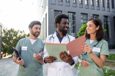 Bir grup doktor. Bir grup genç doktor klinik bahçesinde hasta durumunu tartışıyor ve ilgileniyorlar.