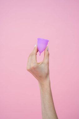 Bilinmeyen kadın elinde silikon bardakla bisiklet hijyenine uygun çevre dostu alternatifler gösteriyor. Pembe arka planda izole edilmiş kadın bakımı.