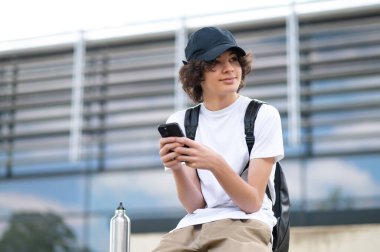 İletişim. Bloklarda oturan ve telefonla iletişim kuran bir genç.