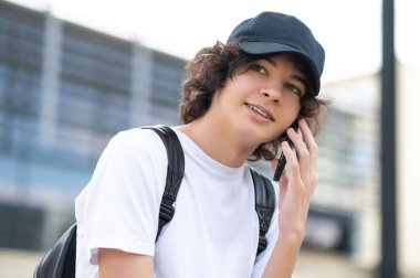 İletişim. Bloklarda oturan ve telefonla iletişim kuran bir genç.