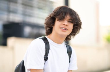 Dersten sonra. Koyu saçlı genç derslerden sonra bloklarda oturup dinleniyor.