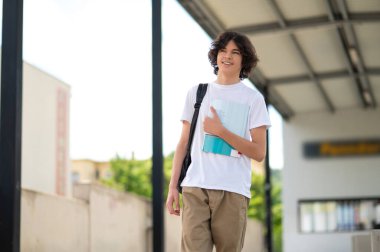 Dersten sonra. Koyu saçlı genç derslerden sonra bloklarda oturup dinleniyor.