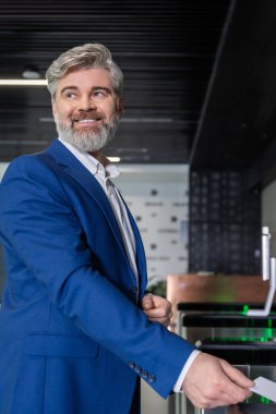 Ofise giriyorum. Koyu mavi takım elbiseli, gri saçlı, olgun bir iş adamı ofise giriş kartıyla giriyor.